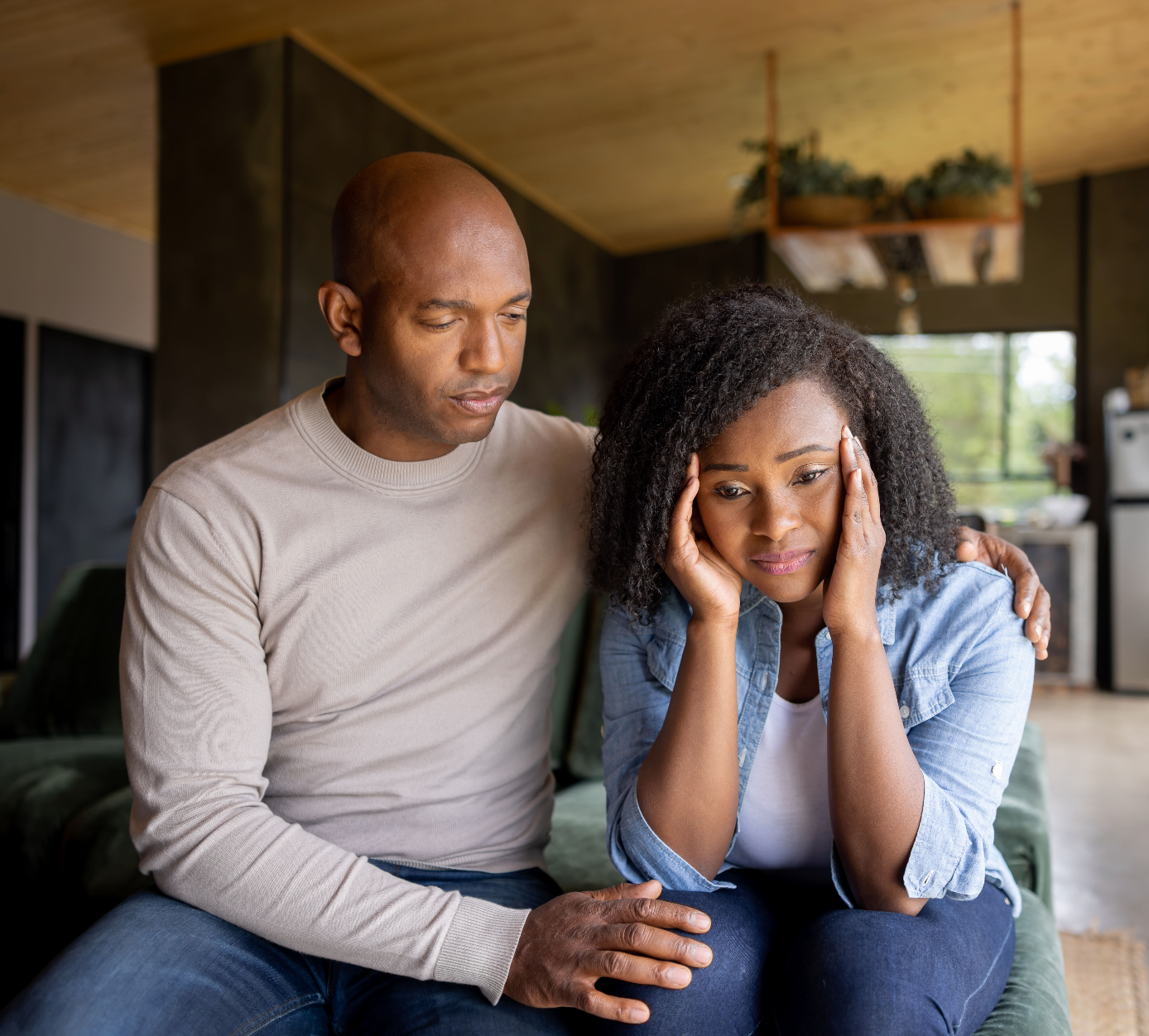A comforting moment between a man and a distressed woman indoors.