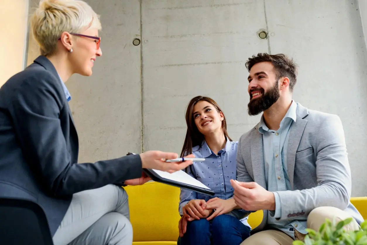 Smiling couple meeting advisor in modern office