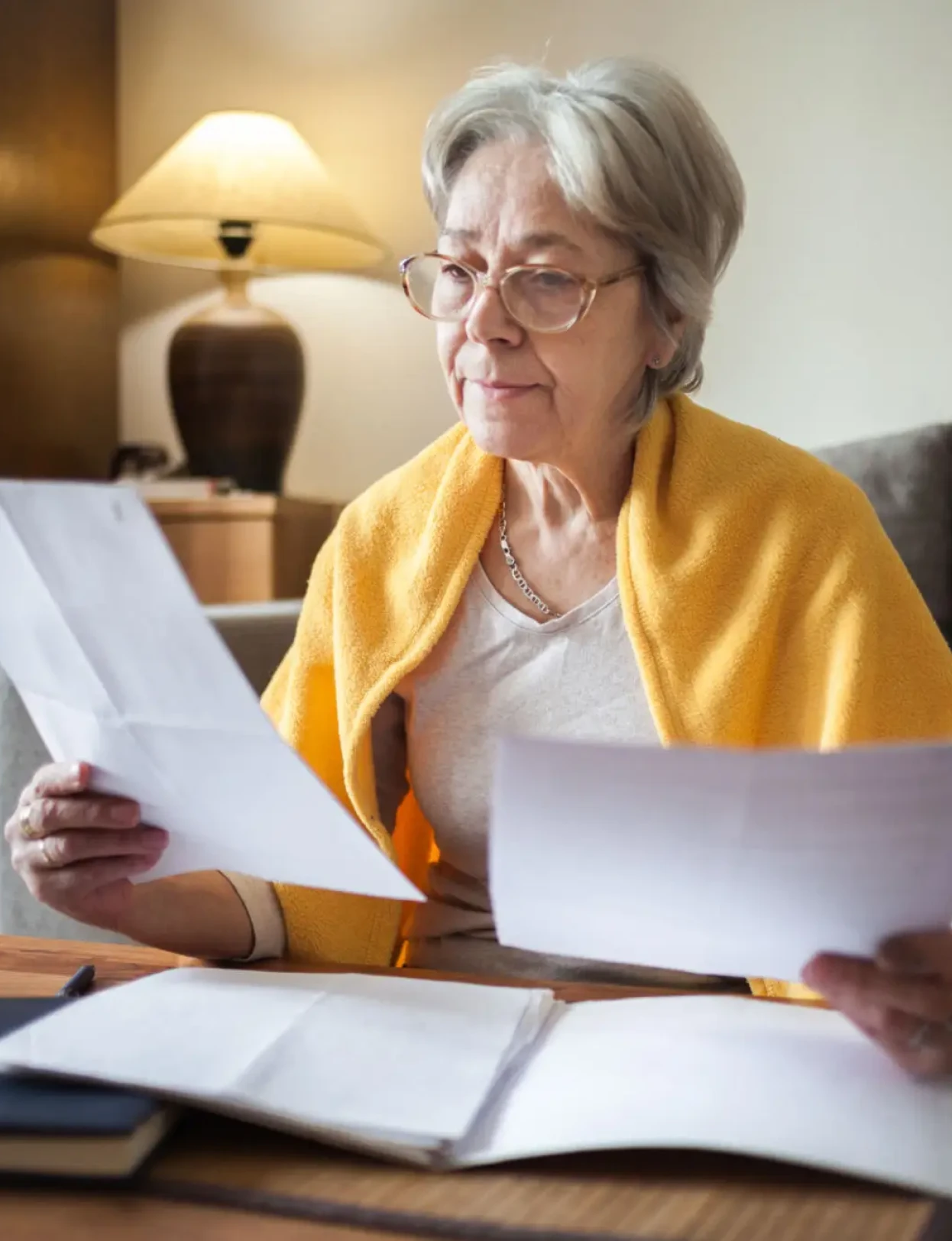 Senior woman reading documents at home